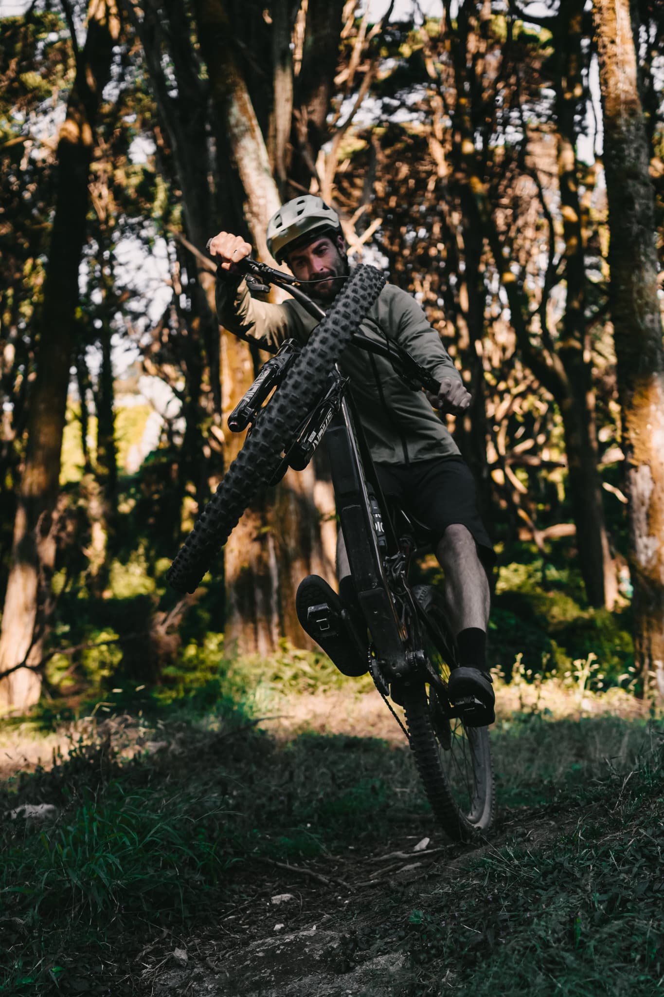 Marcel popping a wheelie on a forest singletrack in Sintra